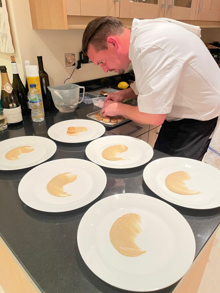 chef getting ready to put scollops on plate