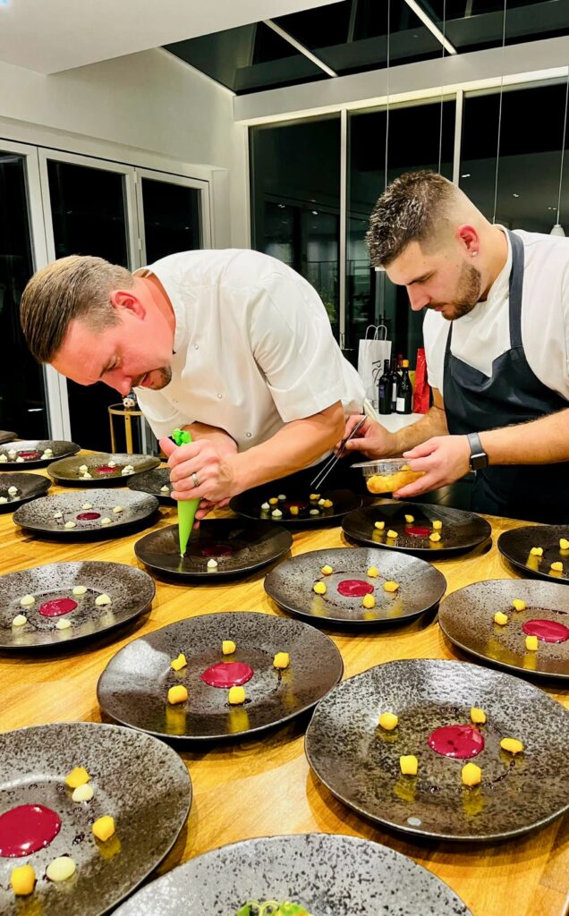 chefs piping dessert onto plate