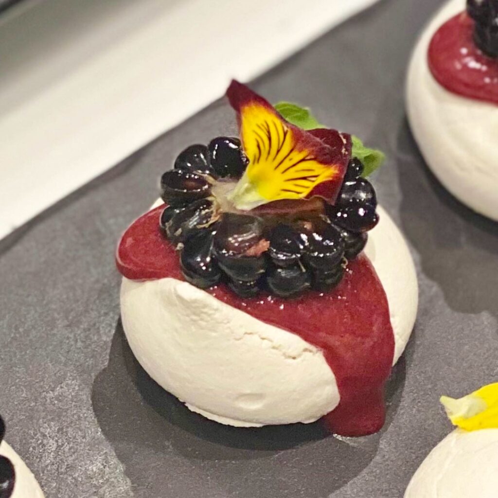 close up of meringue topped with blackberry