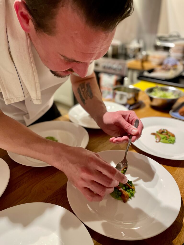 chef putting peas on plate to finish