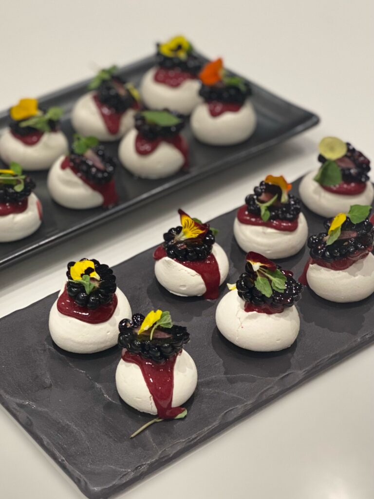 meringues topped with blackberries and purple sauce