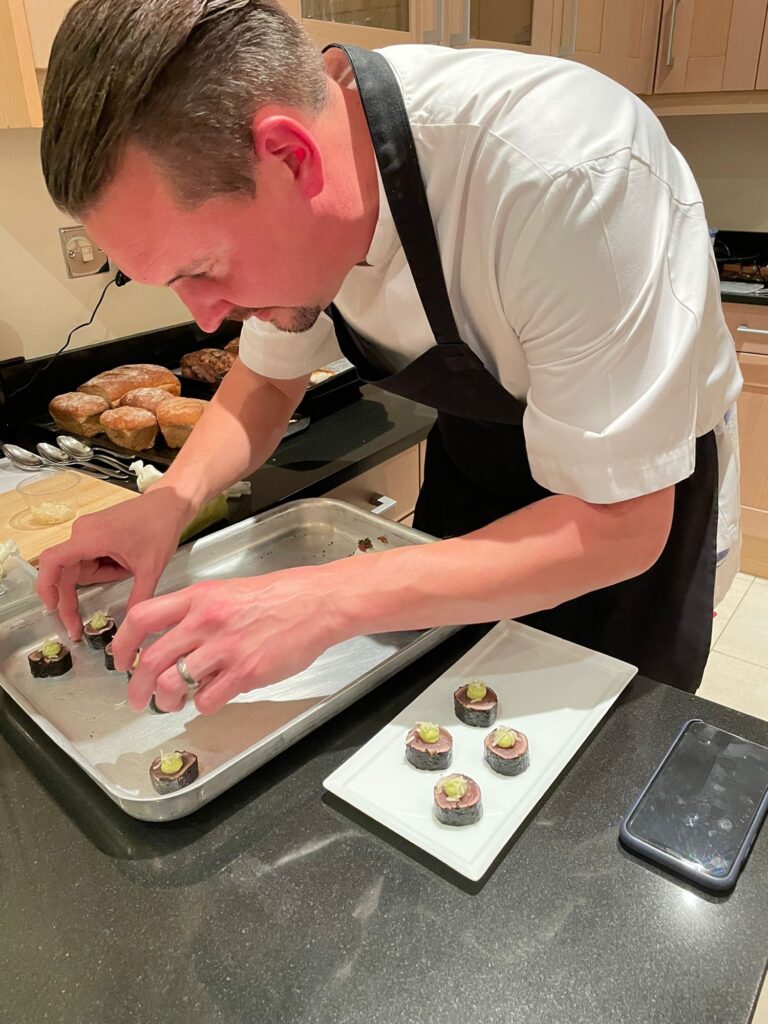 chef lining up small meat canapes